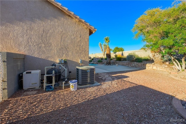 view of yard with a patio area, fence, and central air condition unit