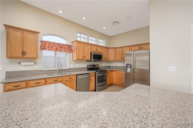 kitchen featuring visible vents, appliances with stainless steel finishes, light stone countertops, a sink, and recessed lighting