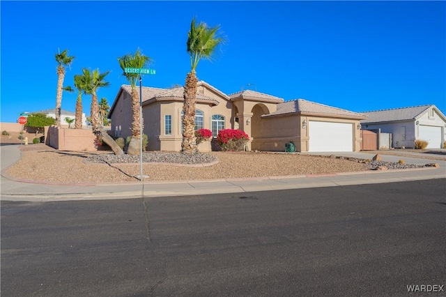 view of front of house featuring driveway, a tiled roof, an attached garage, fence, and stucco siding