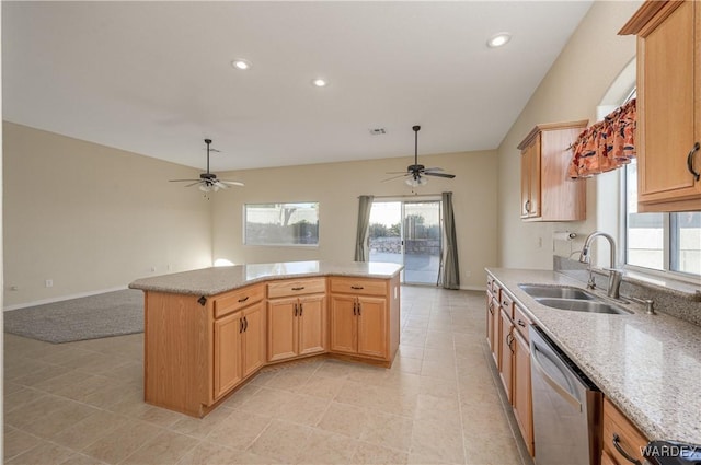 kitchen with light stone counters, a center island, open floor plan, a sink, and dishwasher