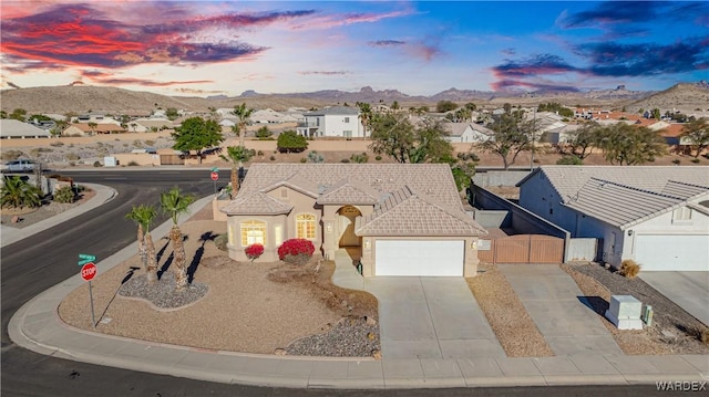 view of front of house with a residential view, a mountain view, driveway, and stucco siding