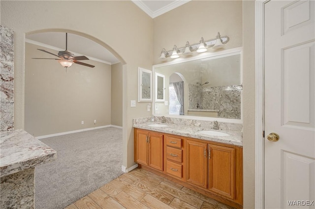 full bathroom with double vanity, a sink, a ceiling fan, and crown molding