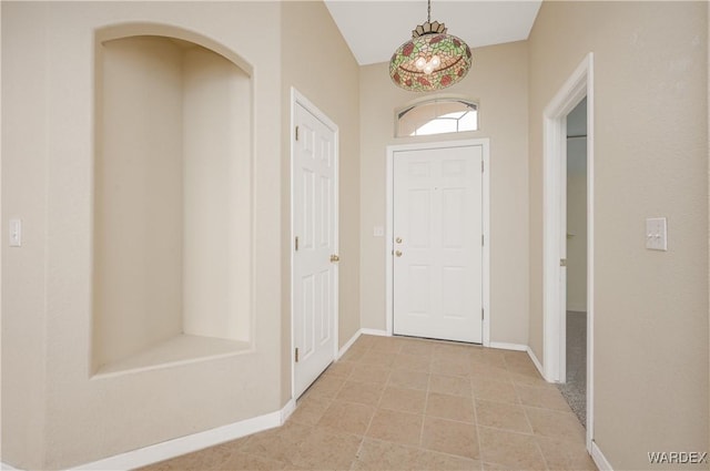 foyer with baseboards and light tile patterned flooring