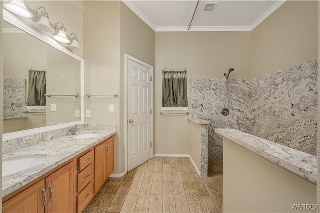 full bathroom featuring crown molding, double vanity, a sink, and wood finished floors