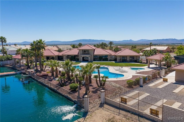 pool featuring a mountain view, a residential view, fence, and a patio area