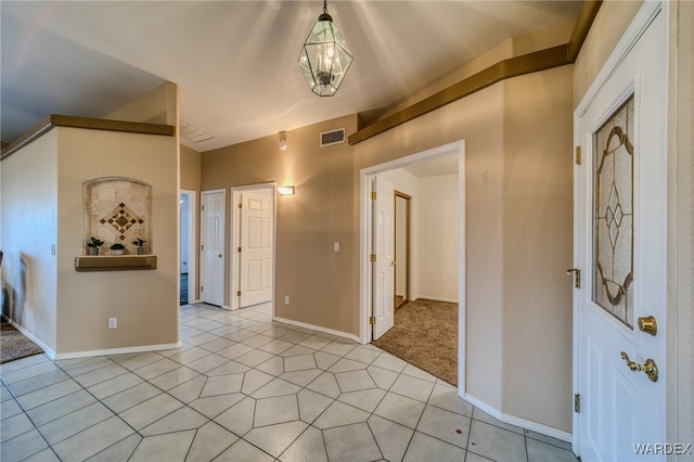 foyer entrance featuring light tile patterned floors, baseboards, and visible vents