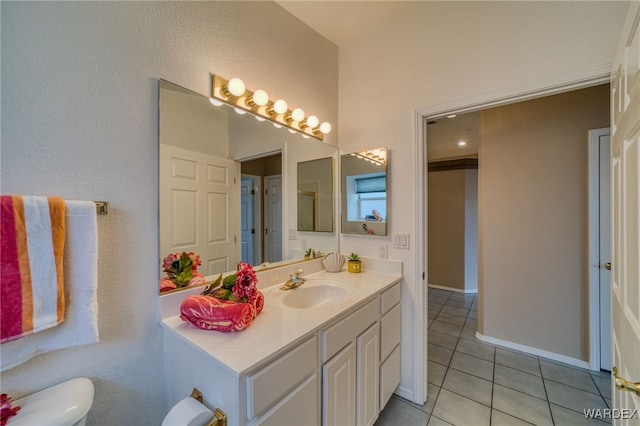 bathroom with tile patterned flooring, toilet, vanity, and baseboards