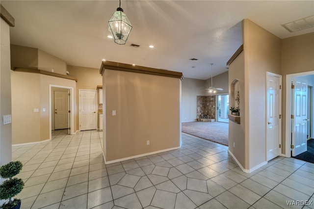 empty room featuring light tile patterned floors, visible vents, ceiling fan, and baseboards