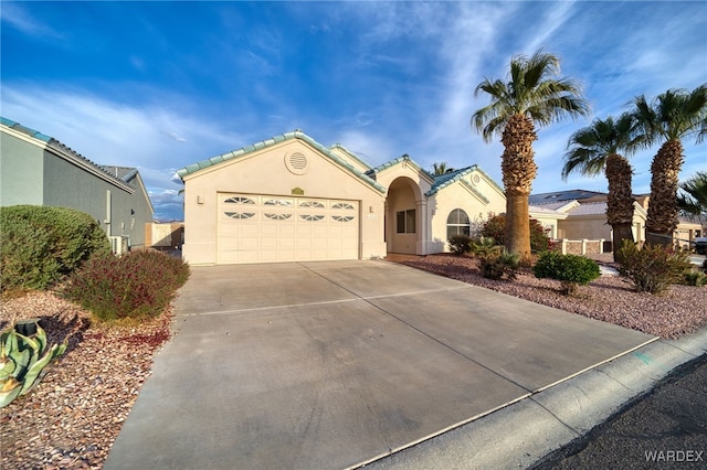 view of front of house featuring fence, a garage, driveway, and stucco siding