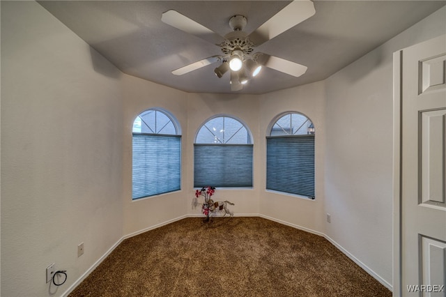 carpeted spare room with baseboards and ceiling fan