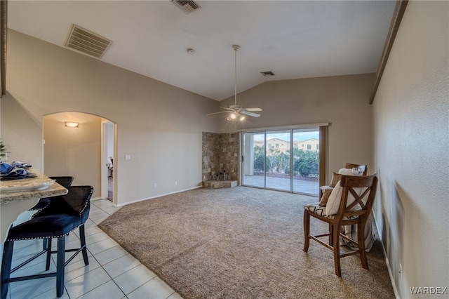 sitting room with arched walkways, visible vents, and light carpet