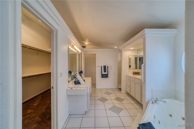 bathroom featuring tile patterned floors, recessed lighting, vanity, a tub with jets, and a spacious closet