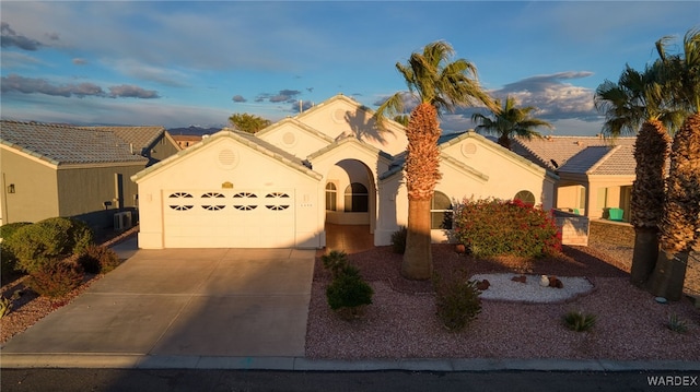 view of front of property with a garage, stucco siding, driveway, and a tiled roof