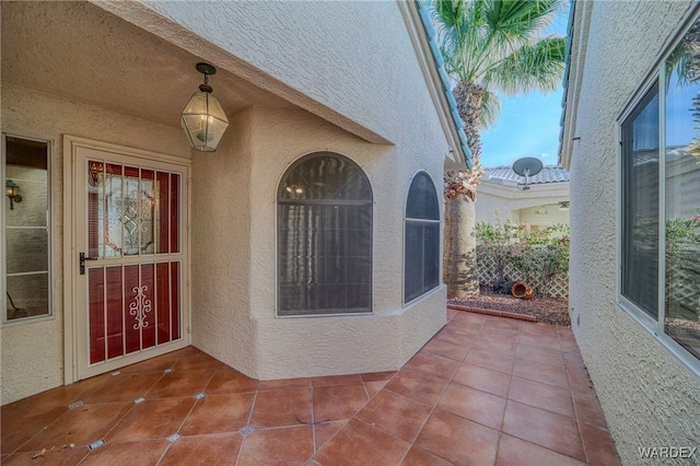 property entrance with stucco siding and a patio