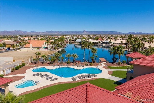 pool featuring fence, a patio area, a residential view, and a water and mountain view