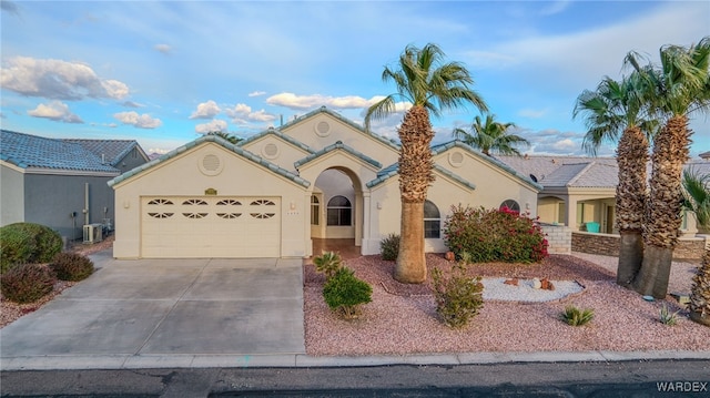 view of front of home featuring a tiled roof, stucco siding, driveway, and a garage