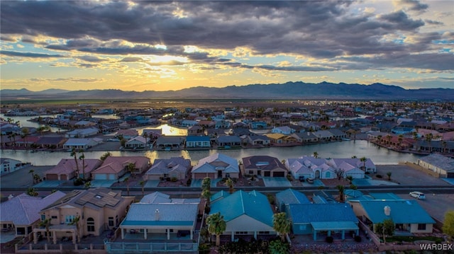 aerial view at dusk with a residential view and a water and mountain view