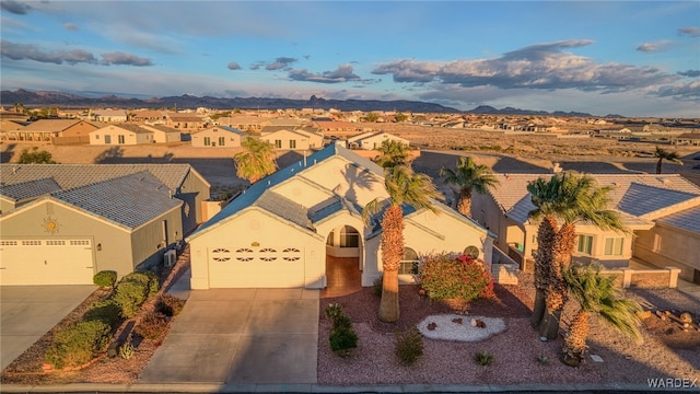 view of front of property with a garage, a residential view, concrete driveway, and stucco siding