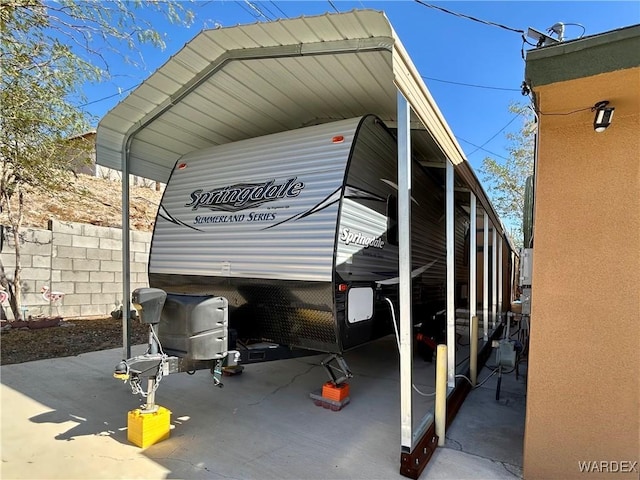 view of vehicle parking with a carport and fence