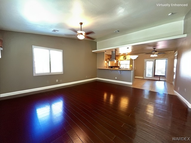 unfurnished living room featuring hardwood / wood-style floors, plenty of natural light, and ceiling fan