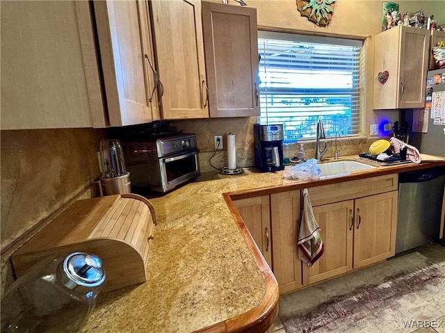 kitchen with a toaster, a sink, light countertops, and stainless steel dishwasher