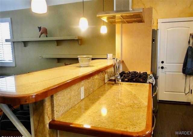 kitchen featuring under cabinet range hood, hanging light fixtures, and light countertops