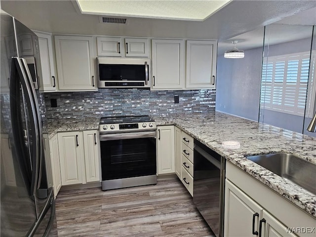 1800 Clubhouse Dr Unit 89, Bullhead City, AZ 86442 - kitchen with backsplash, visible vents, appliances with stainless steel finishes, light wood finished floors, and a sink