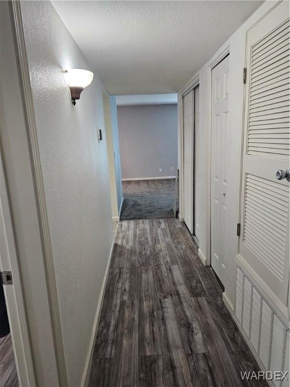 1800 Clubhouse Dr Unit 89, Bullhead City, AZ 86442 - corridor featuring dark wood-type flooring, visible vents, a textured ceiling, and baseboards