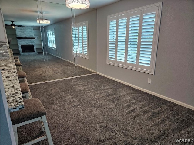 1800 Clubhouse Dr Unit 89, Bullhead City, AZ 86442 - unfurnished living room with ceiling fan, carpet flooring, baseboards, and a fireplace