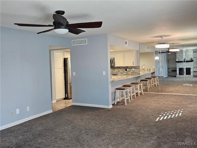 1800 Clubhouse Dr Unit 89, Bullhead City, AZ 86442 - unfurnished living room with visible vents, ceiling fan, carpet floors, and baseboards