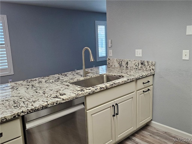 1800 Clubhouse Dr Unit 89, Bullhead City, AZ 86442 - kitchen featuring light wood-type flooring, dishwasher, a sink, and light stone countertops