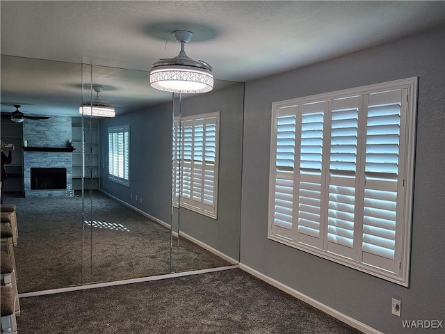 1800 Clubhouse Dr Unit 89, Bullhead City, AZ 86442 - unfurnished dining area with a large fireplace, carpet, baseboards, and ceiling fan