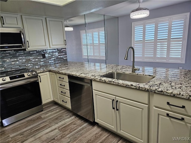 1800 Clubhouse Dr Unit 89, Bullhead City, AZ 86442 - kitchen with a sink, wood finished floors, stainless steel appliances, backsplash, and light stone counters
