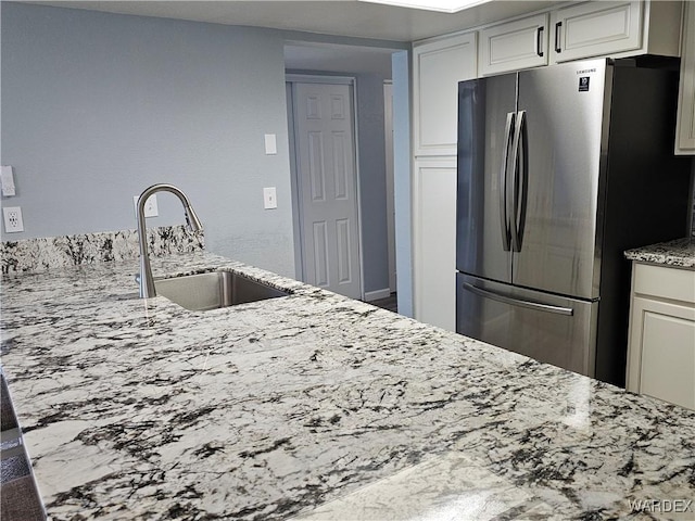 1800 Clubhouse Dr Unit 89, Bullhead City, AZ 86442 - kitchen with a sink, freestanding refrigerator, light stone counters, and white cabinetry