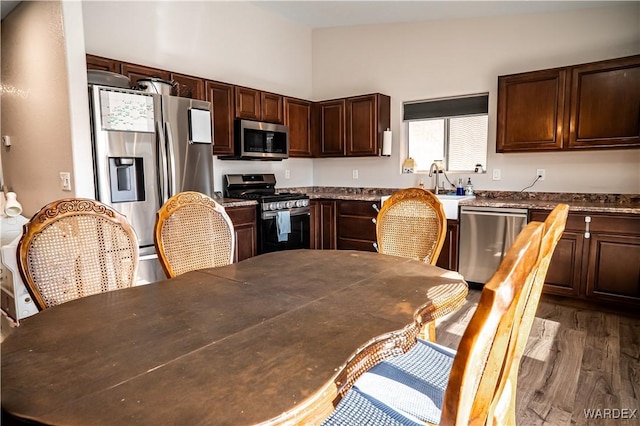 6052 S Bella Vista Dr, Fort Mohave, AZ 86426 - kitchen featuring dark wood-style flooring, dark brown cabinetry, appliances with stainless steel finishes, dark countertops, and a sink