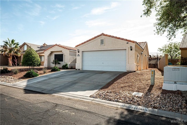 6052 S Bella Vista Dr, Fort Mohave, AZ 86426 - view of front of house featuring an attached garage, stucco siding, driveway, and a tile roof