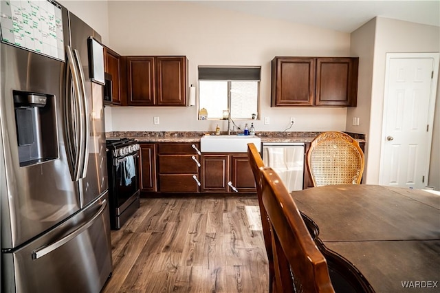 6052 S Bella Vista Dr, Fort Mohave, AZ 86426 - kitchen with wood finished floors, dark brown cabinets, a sink, lofted ceiling, and stainless steel appliances