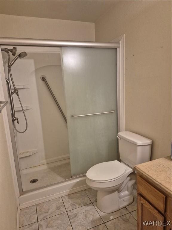 bathroom featuring a stall shower, marble finish floor, toilet, and vanity