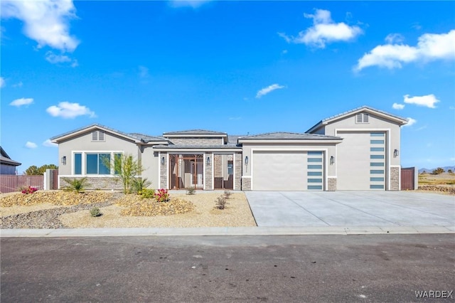 view of front facade featuring stucco siding, fence, a garage, stone siding, and driveway