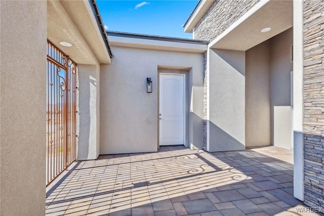 doorway to property with stone siding and stucco siding