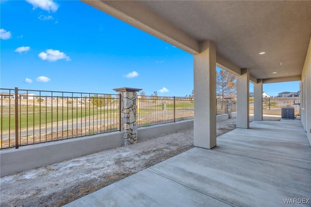 view of patio featuring central AC unit and fence