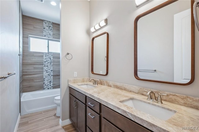 full bathroom with double vanity, a sink, toilet, and shower / bathtub combination