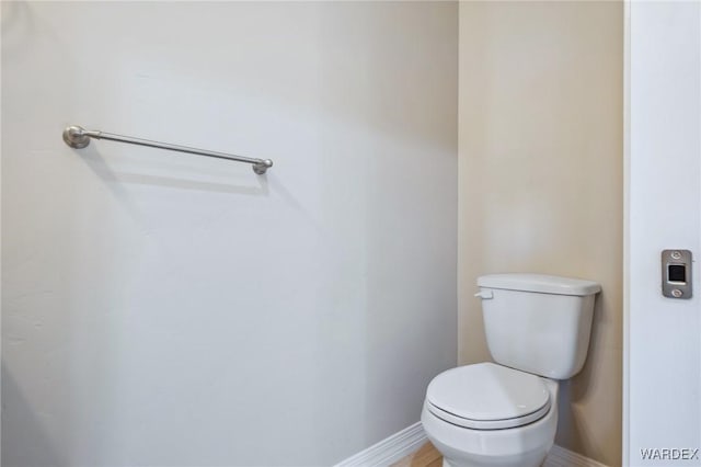 bathroom with baseboards and toilet