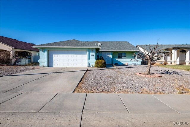 ranch-style home featuring concrete driveway, an attached garage, and stucco siding