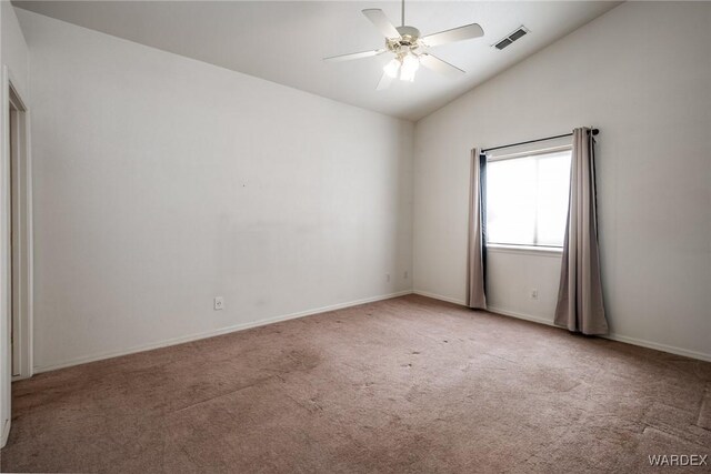 spare room with baseboards, visible vents, a ceiling fan, vaulted ceiling, and carpet floors