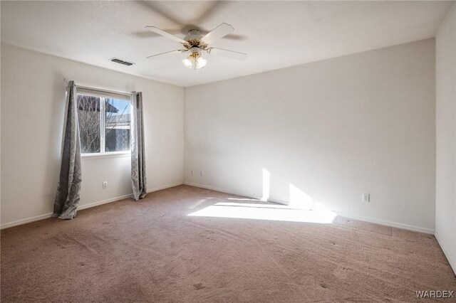 unfurnished room featuring baseboards, carpet, visible vents, and a ceiling fan