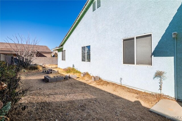 exterior space featuring fence and stucco siding