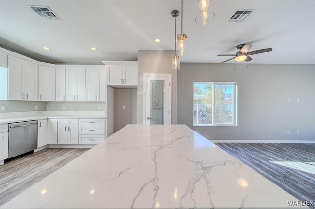 kitchen featuring visible vents, white cabinetry, light stone countertops, dishwasher, and pendant lighting