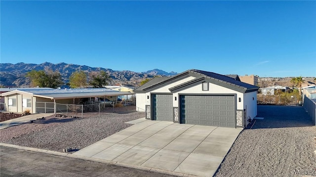 ranch-style house with an attached garage, a mountain view, concrete driveway, and stucco siding