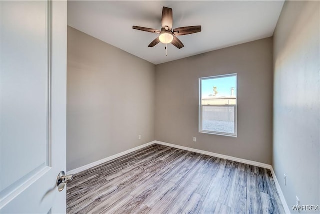 unfurnished room with a ceiling fan, baseboards, and wood finished floors